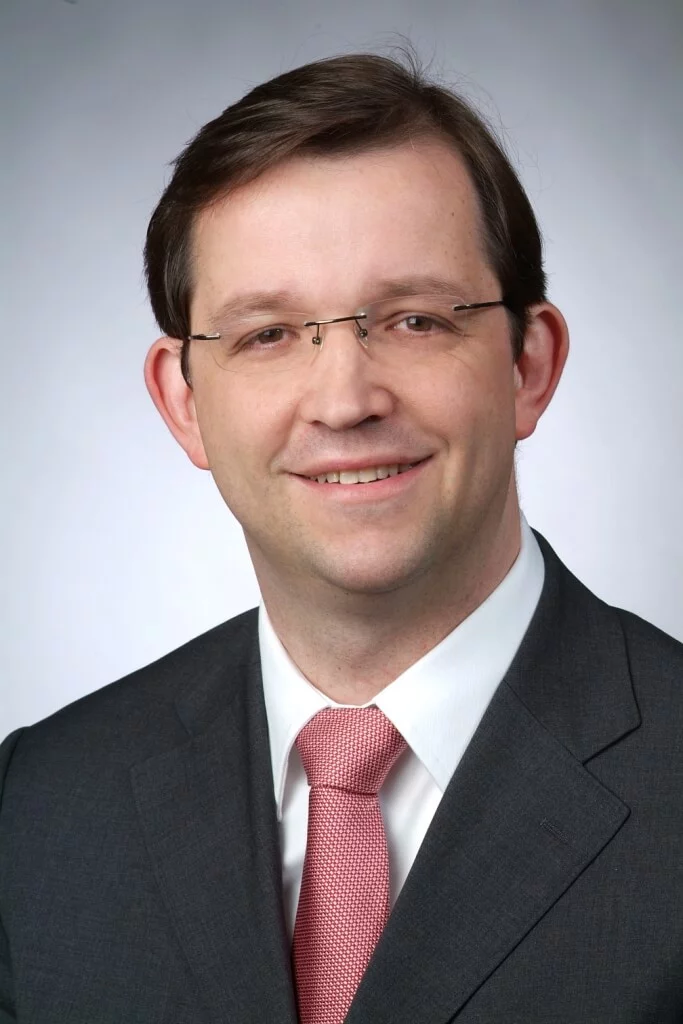 Ein Mann bereitet sich auf einen Geschäftstermin vor und richtet konzentriert seine Krawatte.