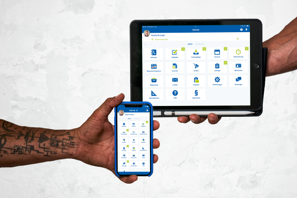 Zwei Hände bedienen Handy und Tablet mit einer App, die Arbeitsaufgaben, Kalender und Nachrichten für den Job anzeigt.